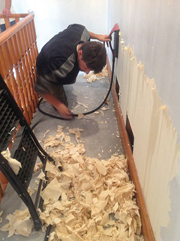 Worker removing wallpaper.